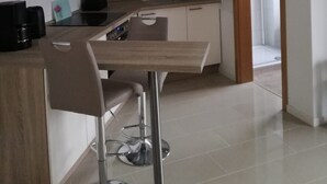 Una cocina moderna con armarios blancos, encimera de madera y pileta de acero inoxidable.