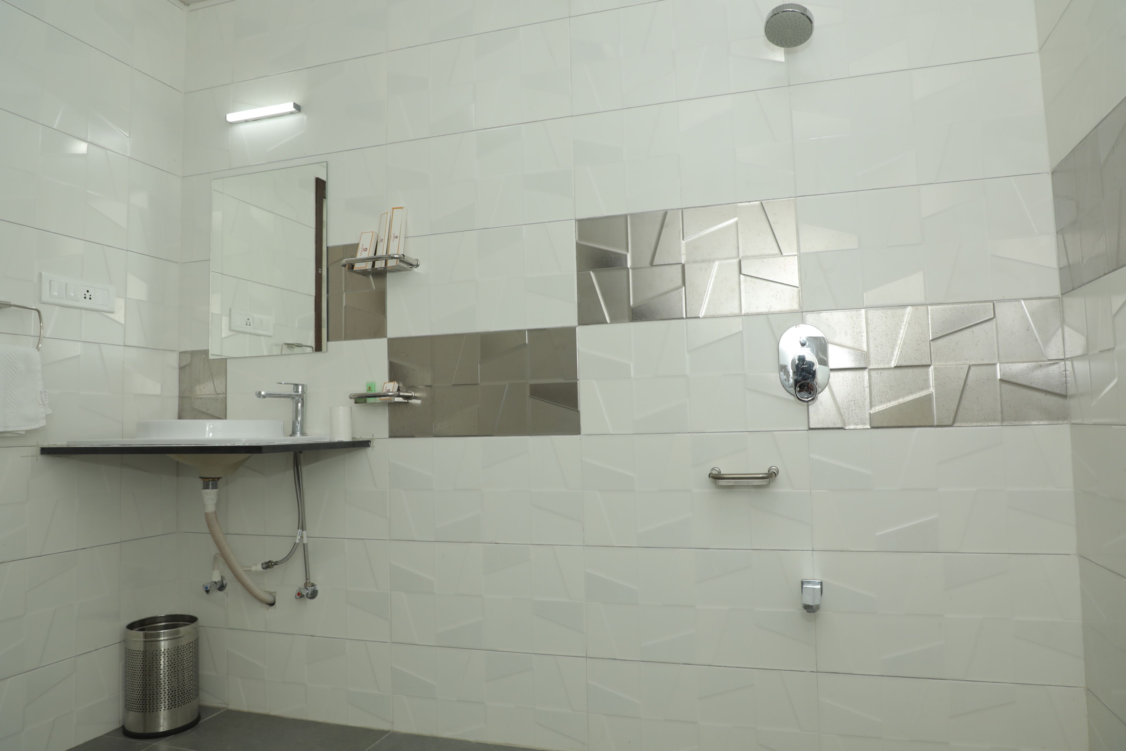 A modern bathroom with a sink, mirror, and shower.