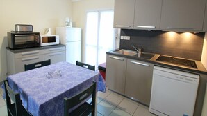 Una cocina compacta equipada con microondas, tostadora, refrigerador y lavavajillas.
