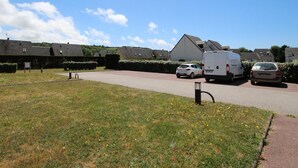 Un barrio residencial con casas, un camino de entrada y coches aparcados.