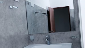 A bathroom with a white sink, a mirror, and a door.
