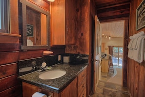 Step into a cozy bathroom with a granite sink and mirror, complete with a convenient towel rack.