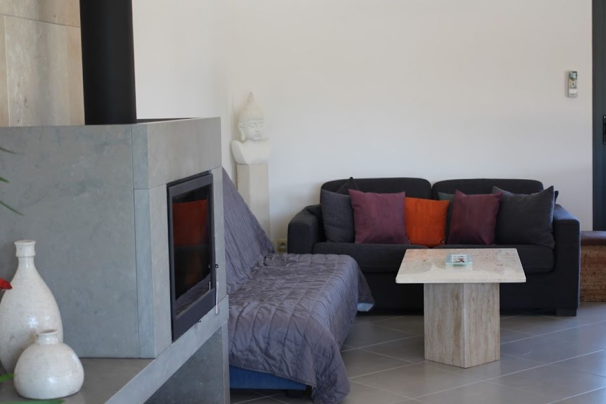 A modern living room with a fireplace, a sofa set, and a coffee table.