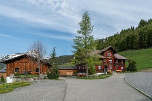 A rural setting with a wooden building and a red house with a sign 'Wieschhof'.