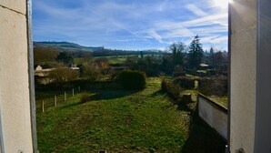A view from a window overlooking a rural landscape with fields, trees, and a distant hill. - IN THE PEACEFUL HEART OF THE VINEYARD (Nolay)