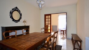 A dining room with a wooden table and chairs, a chandelier, and a mirror on the wall. - IN THE PEACEFUL HEART OF THE VINEYARD (Nolay)