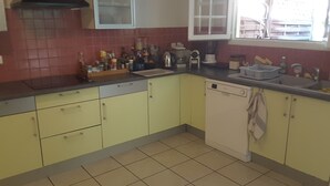 A kitchen with yellow cabinets, a dishwasher, and a window with blinds. - Villa with Caribbean Sea Small Pool (Les Trois-Îlets)