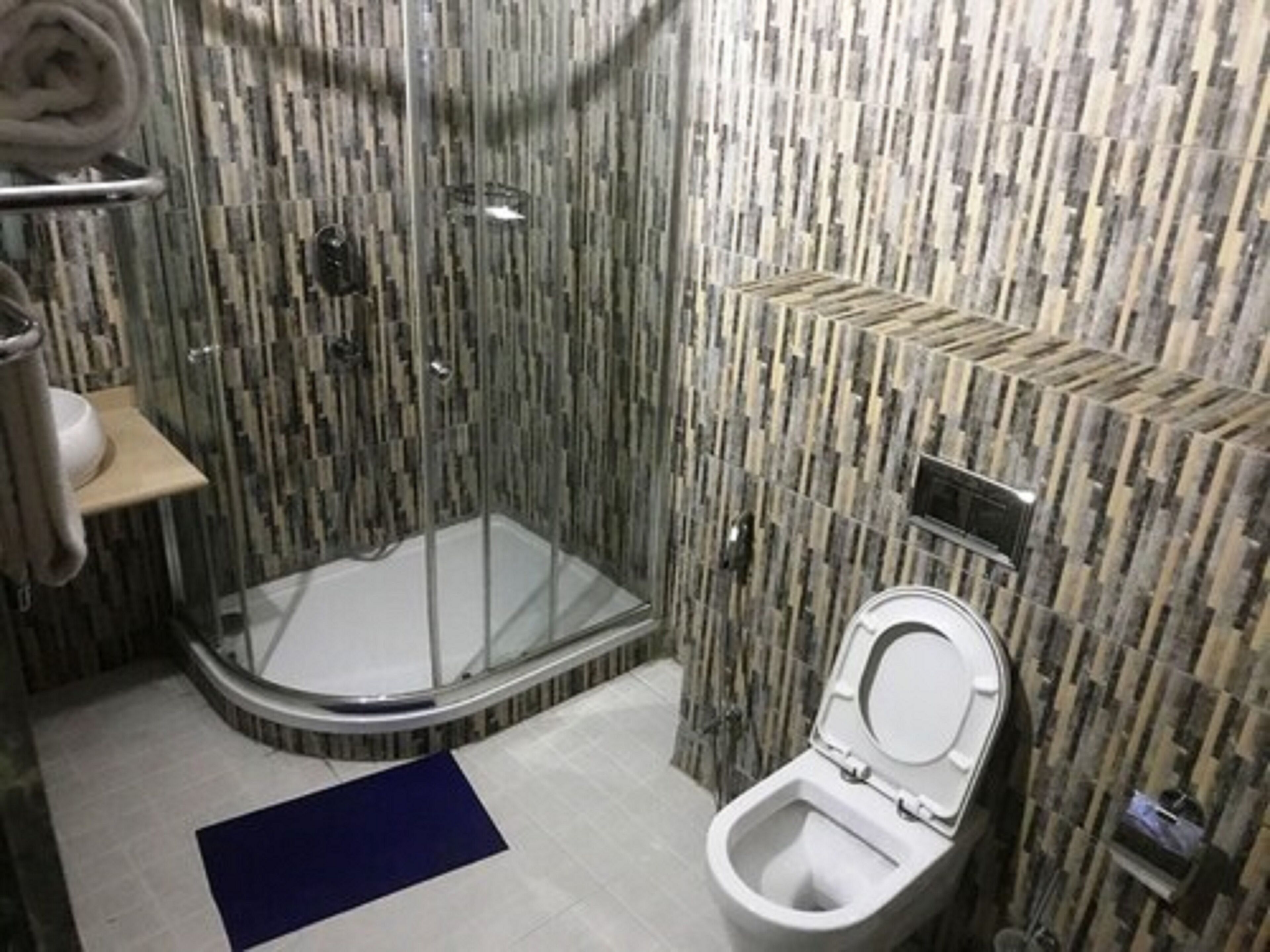 Un bagno con doccia vetro, un water e un lavandino.