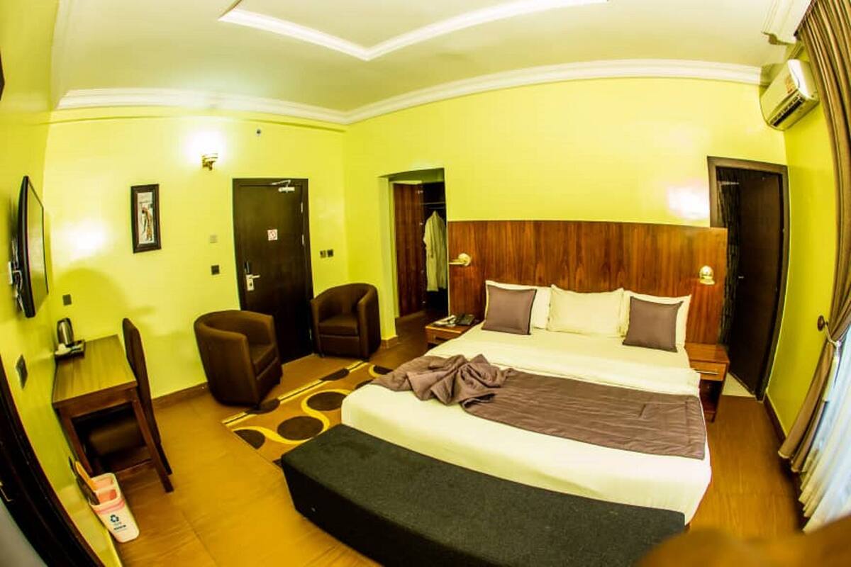 Une chambre d’hôtel équipée d’un lit, d’un bureau, d’une chaise, d’une armoire et d’un téléviseur.