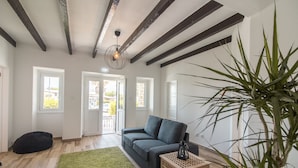 Ein modernes Wohnzimmer mit einem dunkelgrauen Sofa, einem grünen Teppich und einem Holzkisten-Beistelltisch.