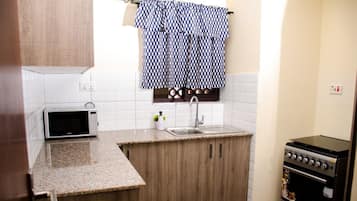 Apartamento superluxo, 2 quartos | Cozinha privada | Geladeira grande, micro-ondas, fogão, cooktop