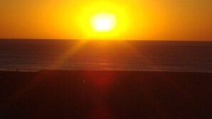 A sunset over the ocean with a clear horizon.
