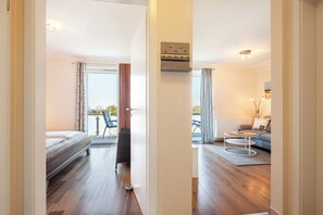 A modern room with a bed, a sofa, a coffee table, and a view of the outdoors. - Whg Hansekogge in the 1st First floor, large balcony with sea view, high quality equipment (Rerik)