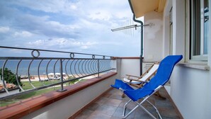 A balcony with a view of the sea, a blue chair, and a metal railing. - House 100 meters from the sea Sardinia (SINISCOLA)