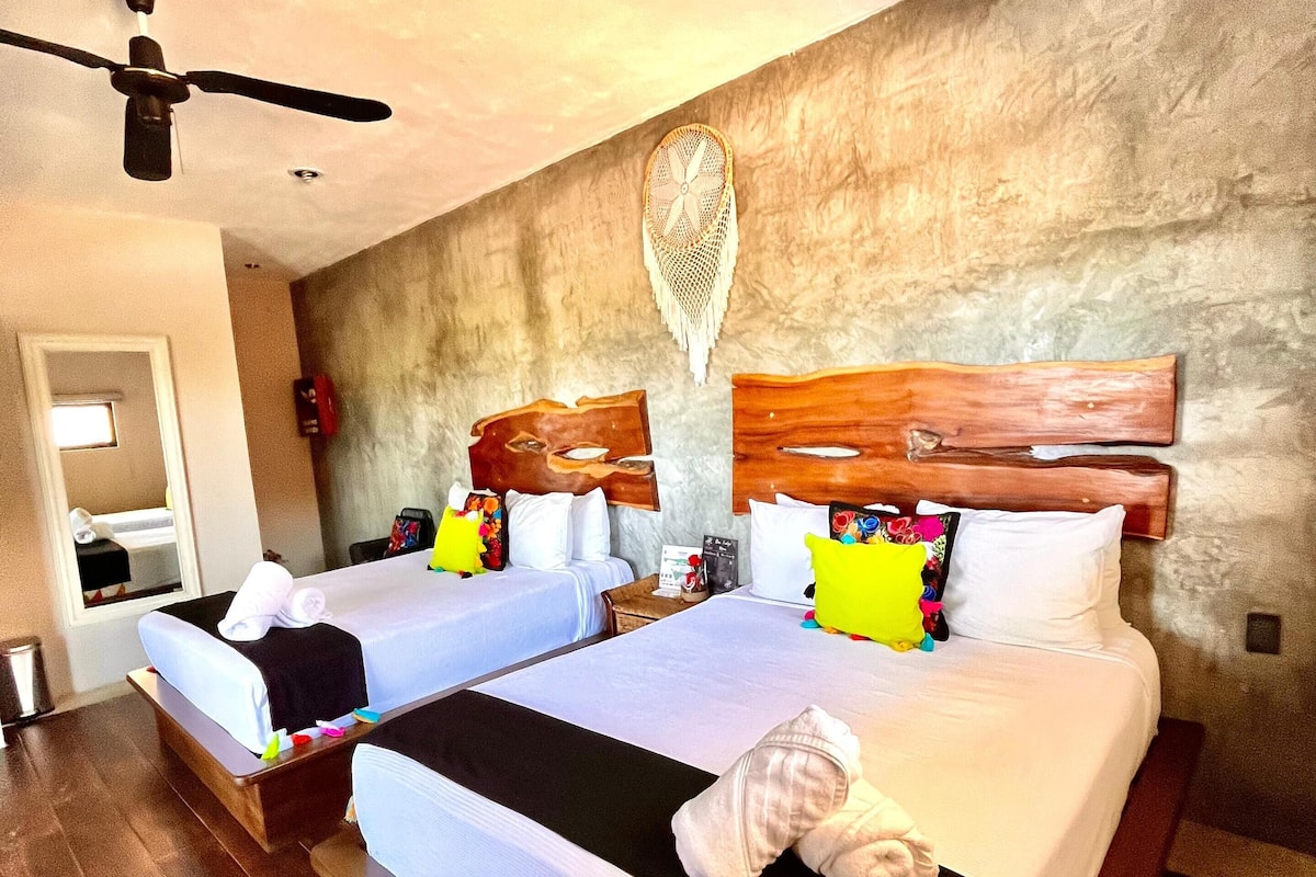 A hotel room with two beds, a ceiling fan, and a textured wall.