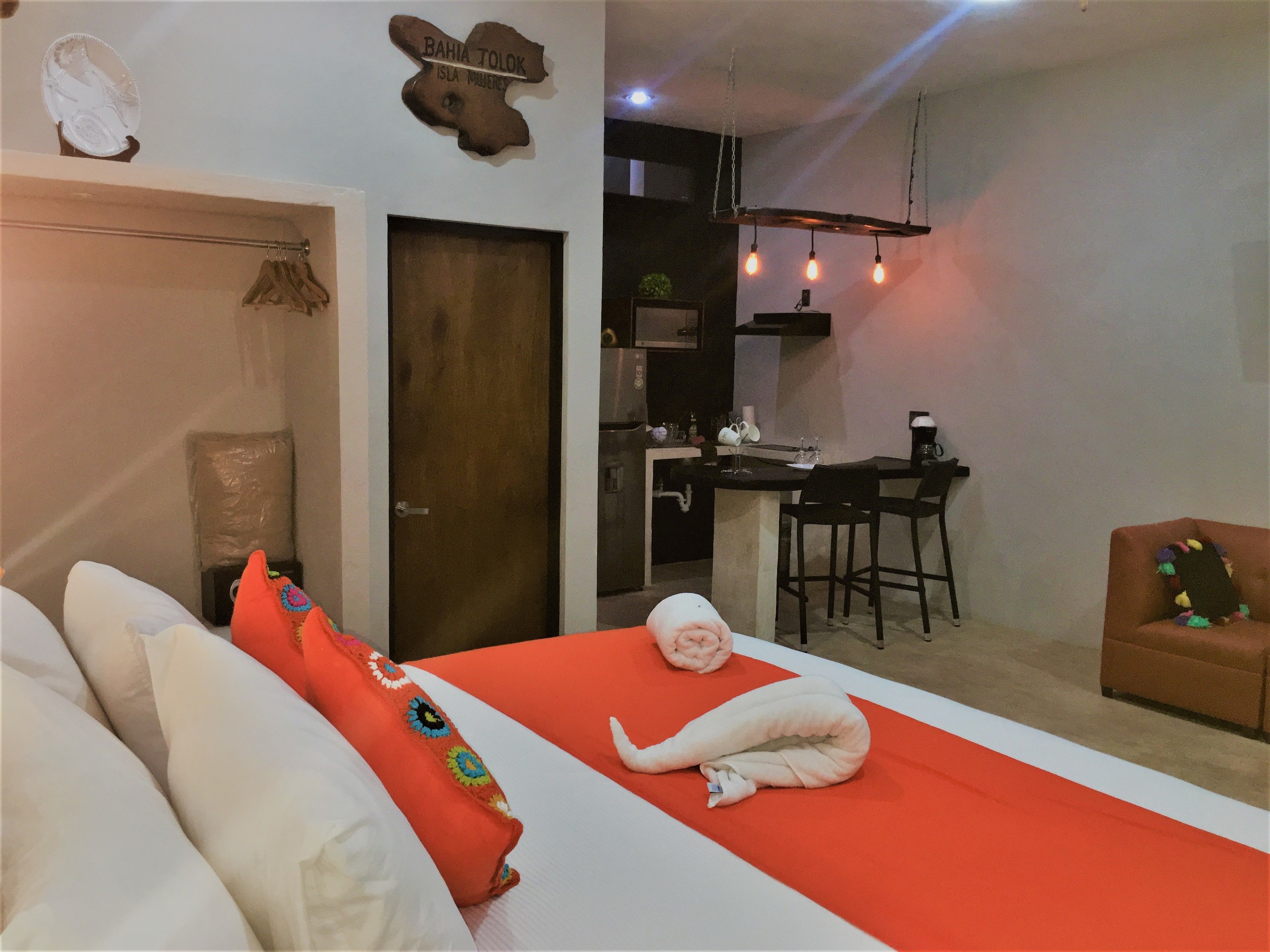 Une chambre d’hôtel de taille réduite, comprenant un lit, une petite kitchenette et un coin repas.