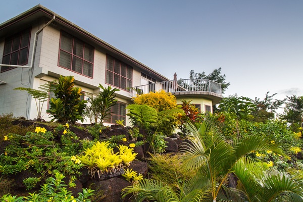 The main house on the hill surrounded by tropical gardens.