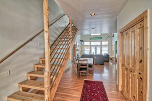 A wooden staircase leading to a living area with a sofa and a dining table. - Beautiful Targhee Farmhouse - Amazing Teton Views (Driggs)