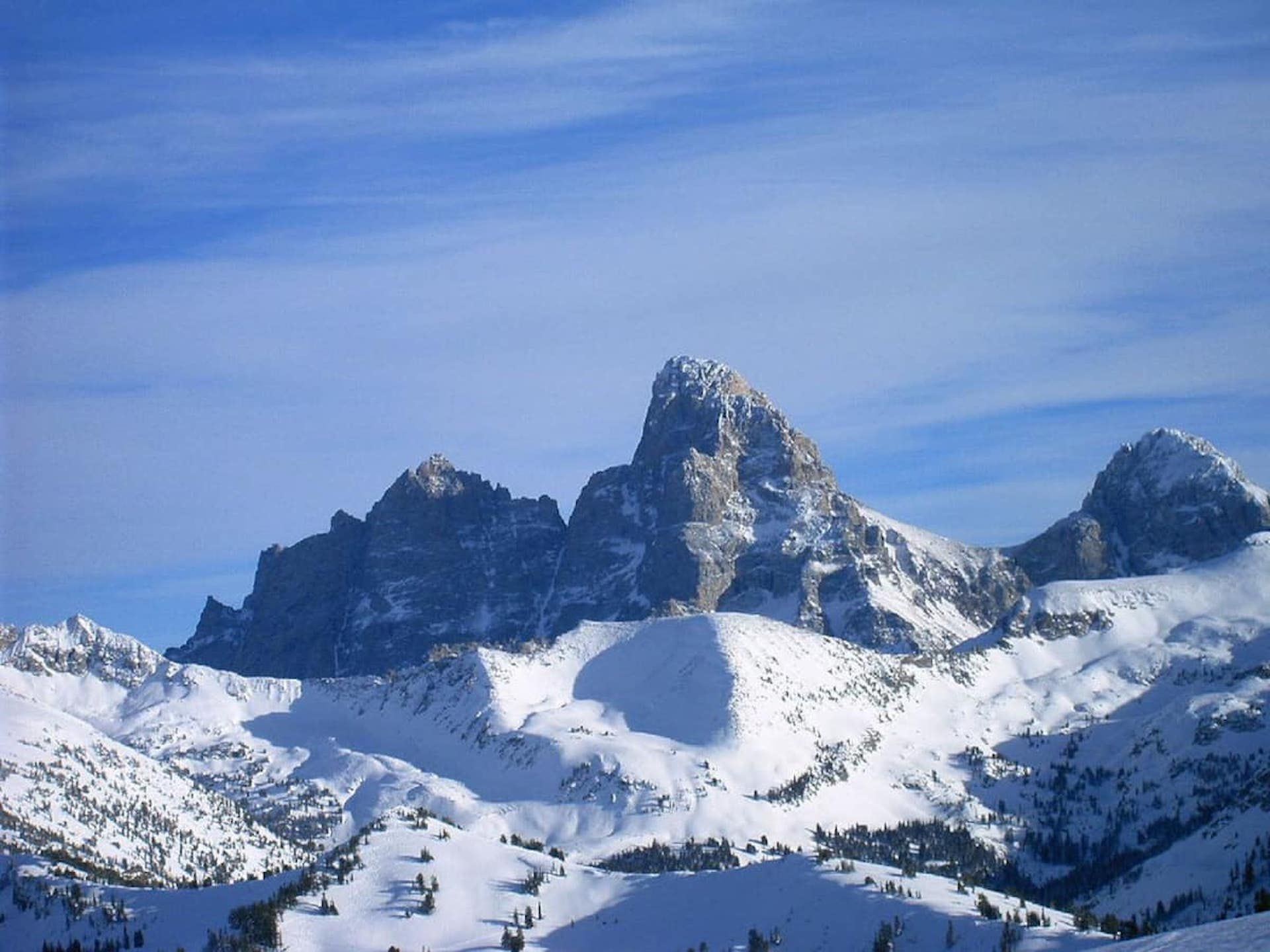 Une chaîne de montagnes enneigée, avec un sommet particulièrement imposant.