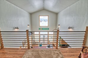 A room with a high ceiling, a wooden railing, a view of a snowy landscape, and a sign indicating a viewpoint. - Beautiful Targhee Farmhouse - Amazing Teton Views (Driggs)