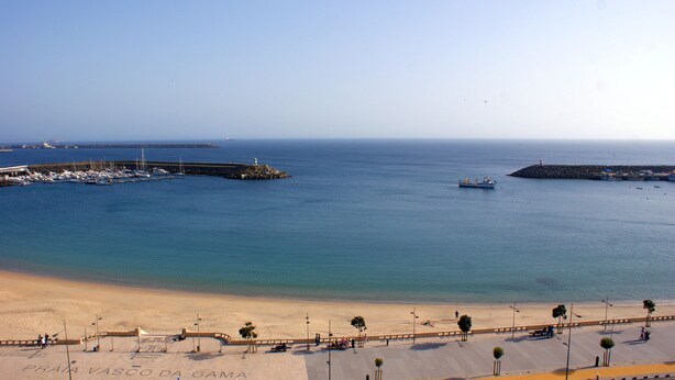 A beach with a promenade, boats, and a lighthouse. - Ana's Apartments, Sea View (Sines)