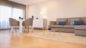 A modern living room with a sofa, two chairs, a coffee table, and a lamp. - Ana's Apartments, Sea View (Sines)