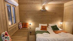 A wooden-paneled room with a bed, pillows, and a nightstand.