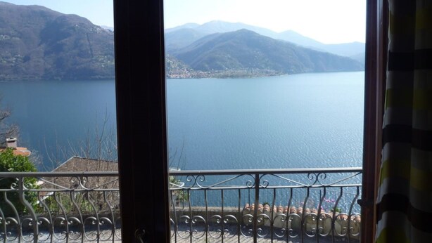 A view from a balcony with a metal railing overlooking a lake and mountains. - Holiday home in southern gardens with breathtaking panoramic views  (Canobio/Carmine)