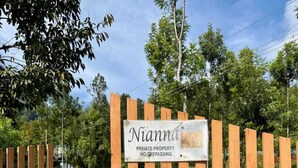 Een houten poort met een bord waarop staat: 'Nianna Private Property No Trespassing'.