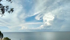 Ein Strand mit freiem Blick auf das Meer und einem entfernten Boot.