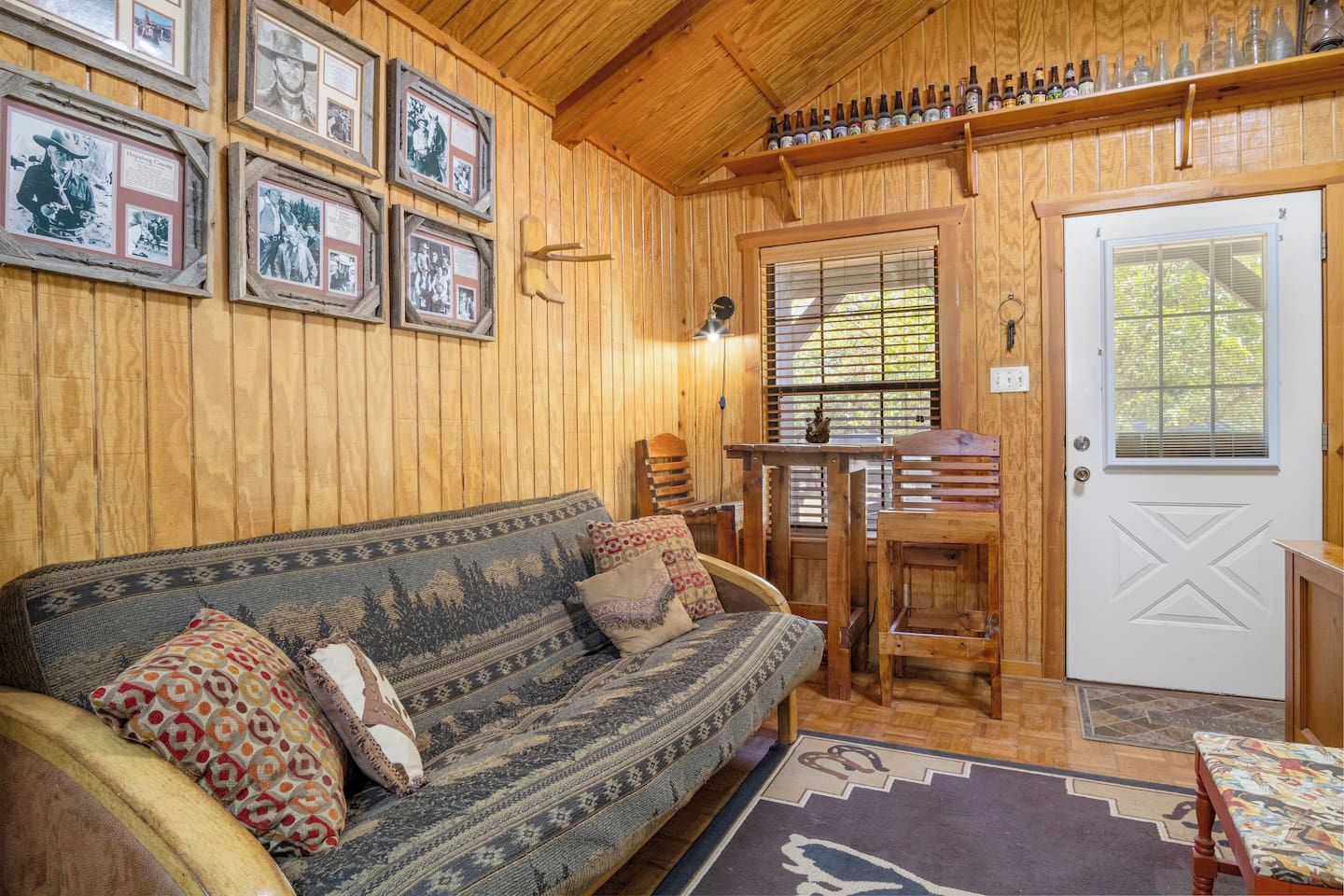 Un interior de madera con un sofá, una mesa y una puerta.
