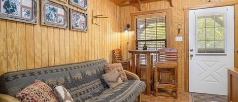 Un interior de madera con un sofá, una mesa y una puerta.
