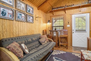 Een houten interieur met een bank, een tafel en een deur.
