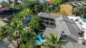 A resort with a pool, palm trees, and a view of the ocean. - Pousada Pérola do Porto (Ipojuca)