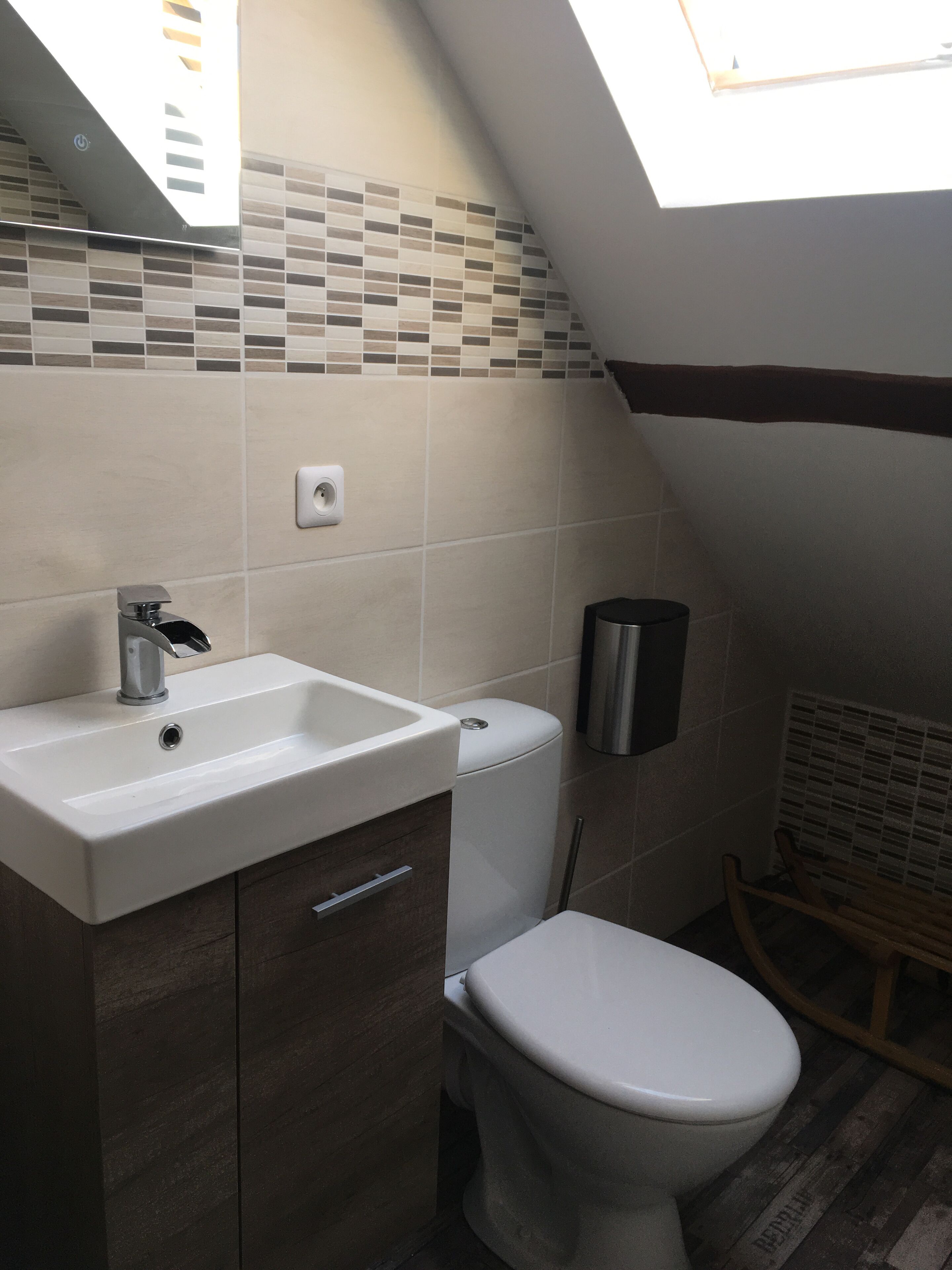 A bathroom with a white sink, a toilet, and a shower area.