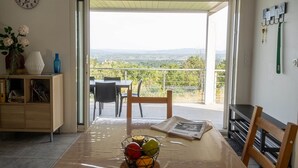 A dining area with a table, chairs, and a view of the outdoors.