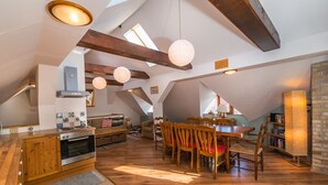 Ein geräumiges Dachzimmer mit Küche, Essbereich und Bücherregalen.