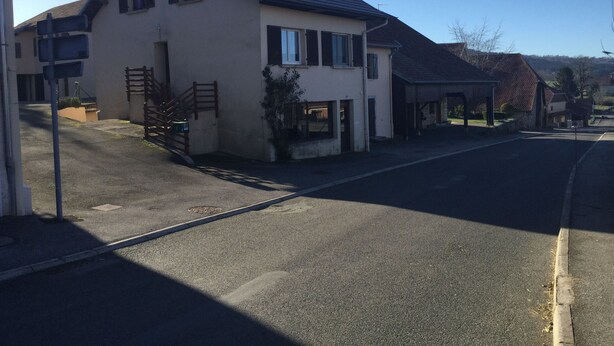 A two-story house with a sloped roof, a front porch, and a garage. - Cozy house in the countryside (Bolandoz)