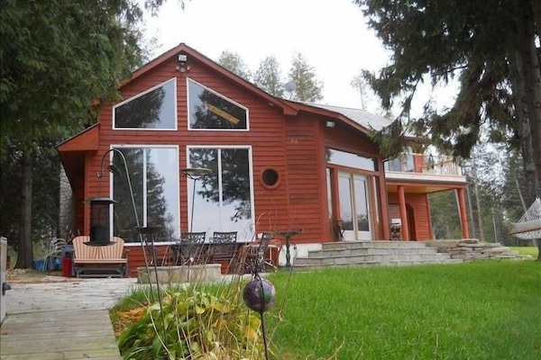 Apple Unit with large windows towards the water, outside patio with a fire pit
