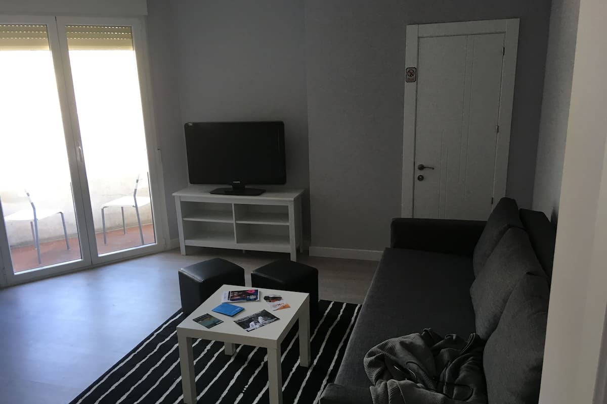 Escritorio, cortinas blackout y tabla de planchar con plancha
