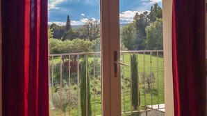 Ein Zimmer mit einer Schiebetür aus Glas, die auf einen Balkon mit Metallgeländer führt.