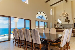 Enjoy meals in this elegant dining area with a large table, six comfortable chairs, and a stunning ocean view.