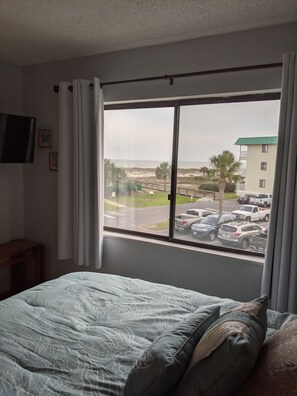 Enjoy a comfortable stay with a view of the city from this hotel room, featuring a bed and TV.