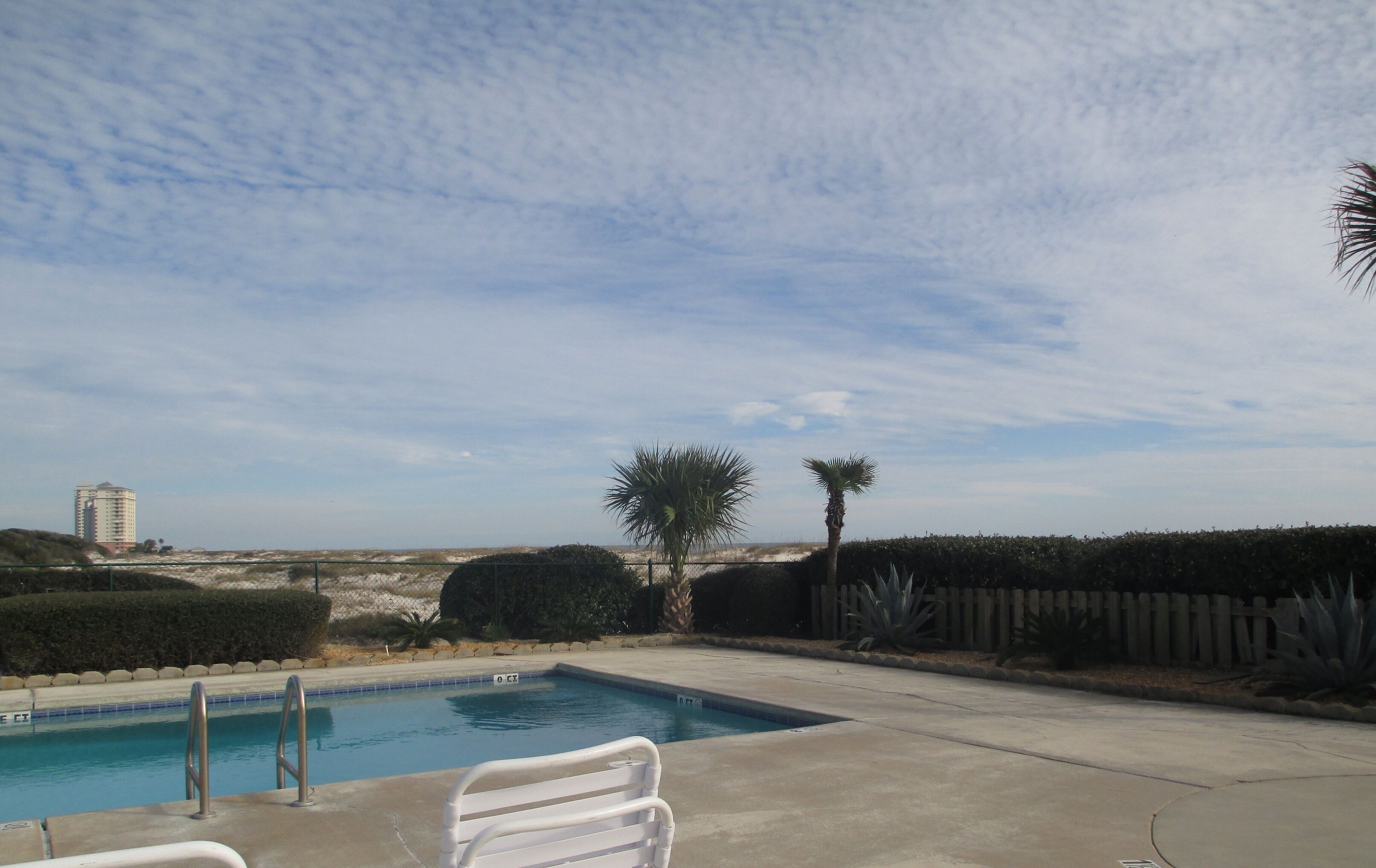 A swimming pool with a view of a distant building and a clear sky.