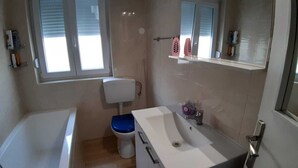 Ein Badezimmer mit einer Badewanne, Toilette und Waschbecken.