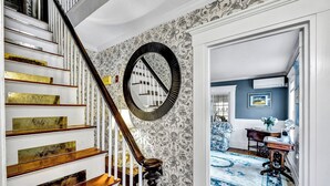 Un escalier orné de rampes en laiton et surmonté d’un miroir.