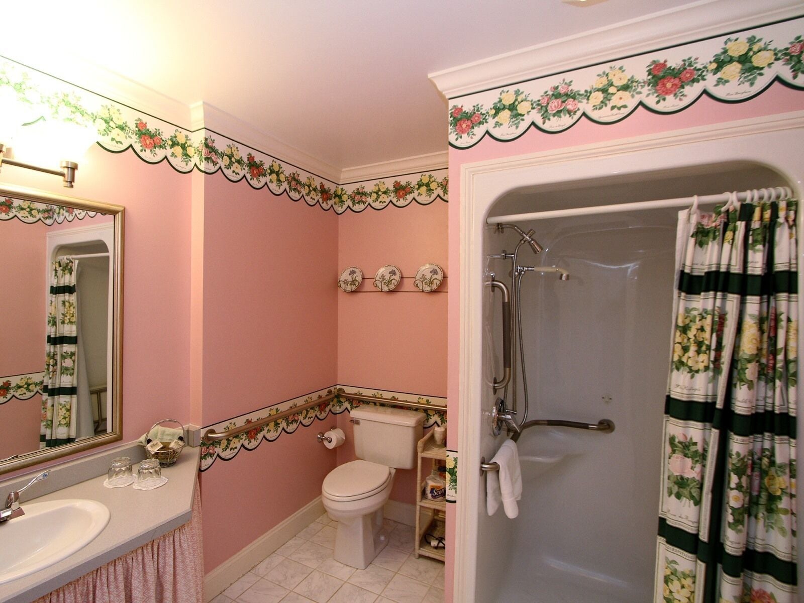 A bathroom with a toilet, sink, and shower.