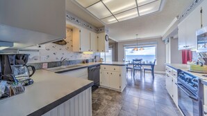 A modern kitchen with a central island, built-in appliances, and a view to the dining area. - Condo #29 has AMAZING unsurpassed views of the Pacific Ocean! (Lincoln City)