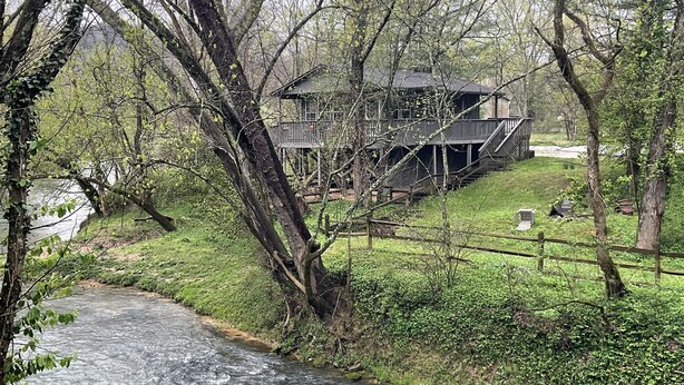 A rustic cabin with a wooden deck and a river in the foreground. - Waterfront 2 Bd cabin on Blue River, PRIVATE RIVER ACCESS, kayaking, fishing (Corydon)
