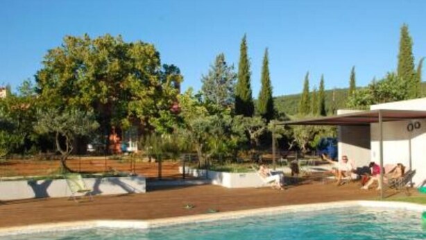 A swimming pool with a wooden deck, surrounded by trees and a covered area with people. - House / Villa - AUPS (Aups)